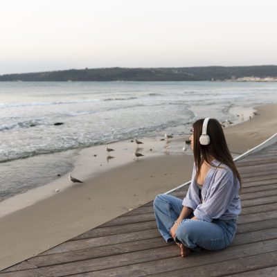 side-view-woman-listening-music-sea